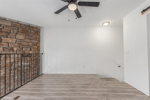 3281 S Estes St, Lakewood, CO 80227 - empty room featuring ceiling fan, wood finished floors, and a barn door