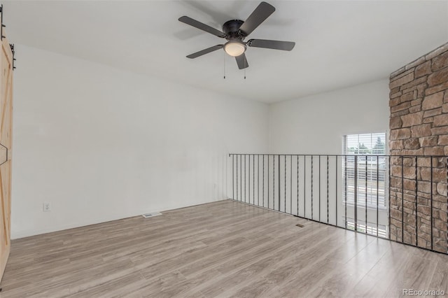3281 S Estes St, Lakewood, CO 80227 - unfurnished room featuring wood finished floors, ceiling fan, and a barn door