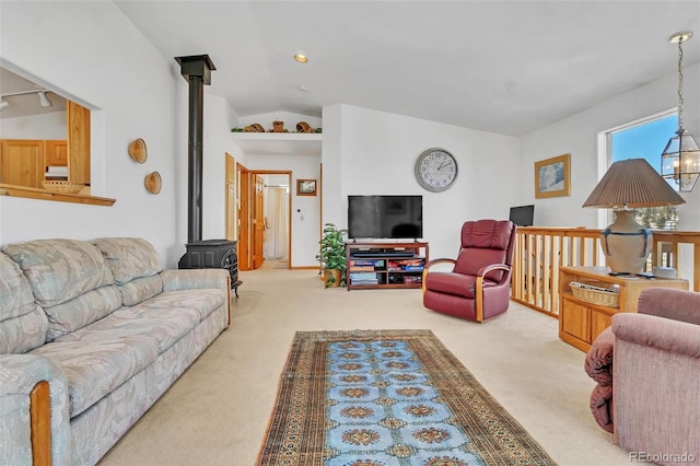 carpeted living room with lofted ceiling and a wood stove