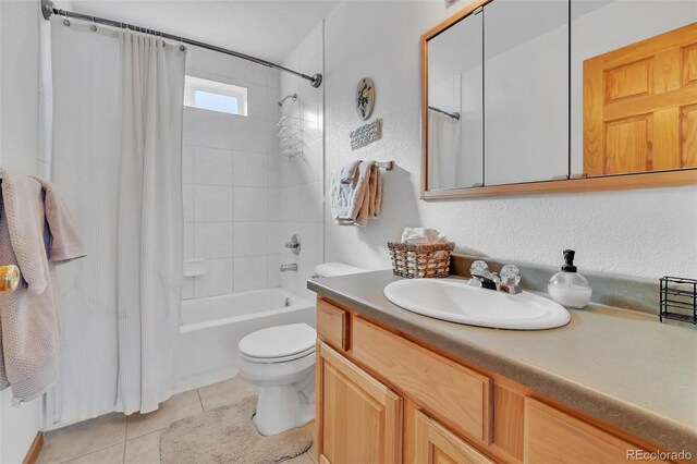 full bathroom featuring tile patterned flooring, vanity, toilet, and shower / bath combo with shower curtain