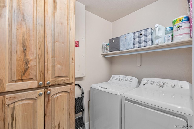 laundry room with washing machine and clothes dryer and cabinet space