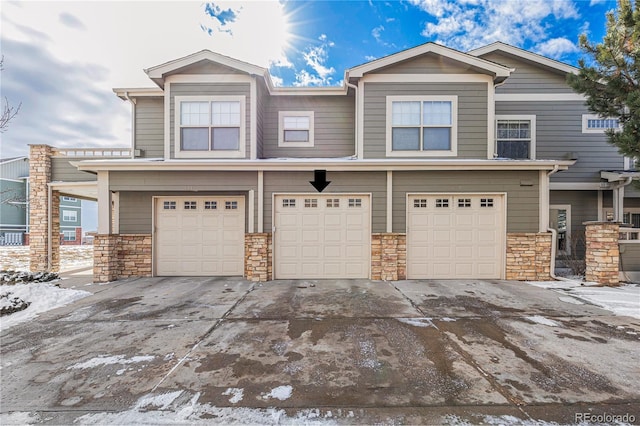 view of front of property with a garage, stone siding, and driveway