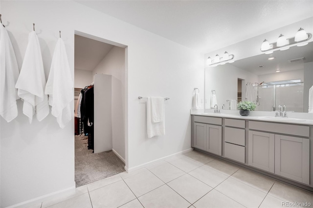 16673 E Virginia Ave, Aurora, CO 80017 - bathroom with double vanity, a shower stall, a spacious closet, tile patterned flooring, and baseboards