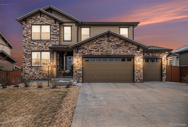 traditional-style home featuring an attached garage, fence, and driveway