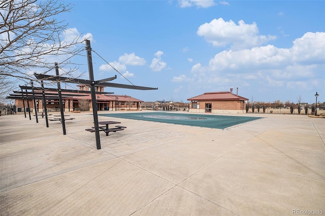 community pool with a patio area and an outdoor structure