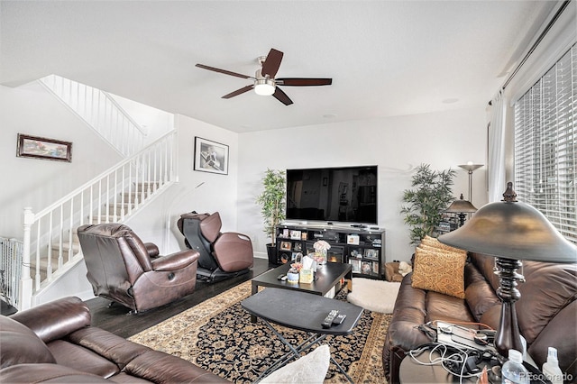 living room featuring a ceiling fan, wood finished floors, and stairs