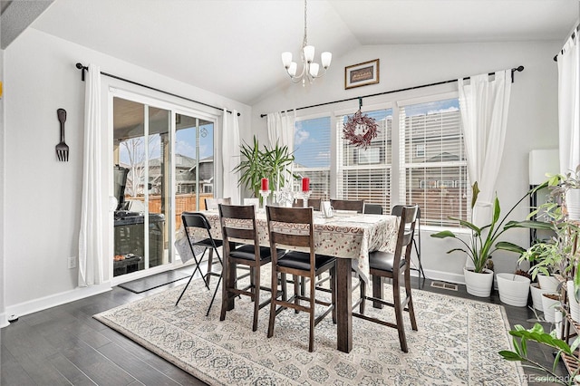 dining area featuring a chandelier, baseboards, wood finished floors, and vaulted ceiling