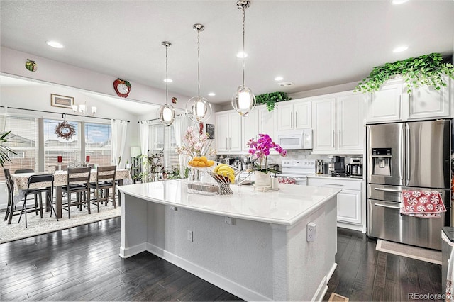 kitchen featuring white appliances, decorative backsplash, dark wood-type flooring, white cabinetry, and a center island