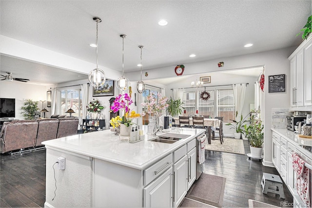 kitchen with open floor plan, light countertops, dark wood-style floors, white cabinetry, and stainless steel dishwasher