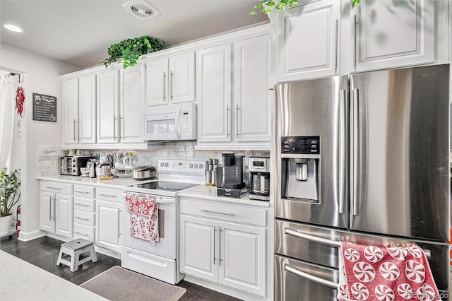 kitchen featuring visible vents, white appliances, white cabinetry, and light countertops