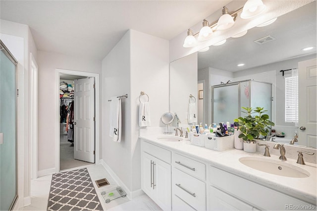 full bath with visible vents, a stall shower, and a sink