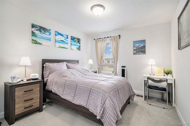 bedroom with light colored carpet, a textured ceiling, and baseboards