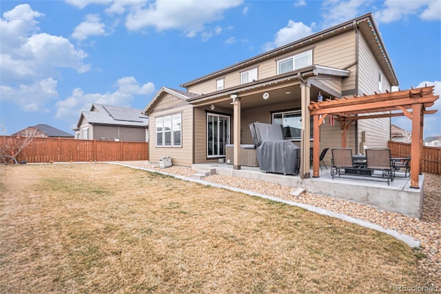 back of property with a patio area, a yard, a pergola, and a fenced backyard