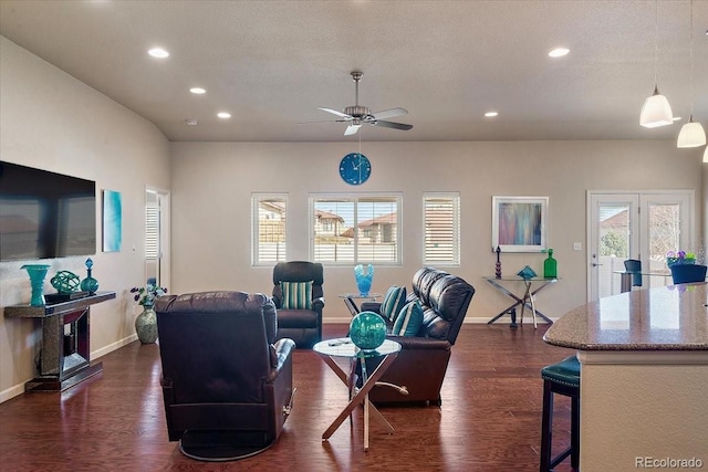 living room featuring a textured ceiling, plenty of natural light, dark wood-type flooring, and ceiling fan