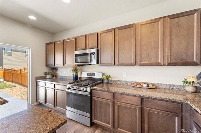 19131 E 65th Ave, Denver, CO 80249 - kitchen with stainless steel appliances, light wood-type flooring, light stone counters, and recessed lighting
