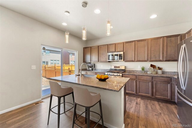 19131 E 65th Ave, Denver, CO 80249 - kitchen with stainless steel appliances, a sink, dark wood-style floors, light stone countertops, and recessed lighting