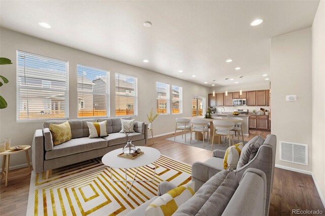 19131 E 65th Ave, Denver, CO 80249 - living room featuring baseboards, recessed lighting, and light wood-style flooring