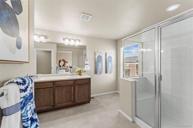 19131 E 65th Ave, Denver, CO 80249 - full bathroom featuring baseboards, a stall shower, double vanity, and tile patterned floors