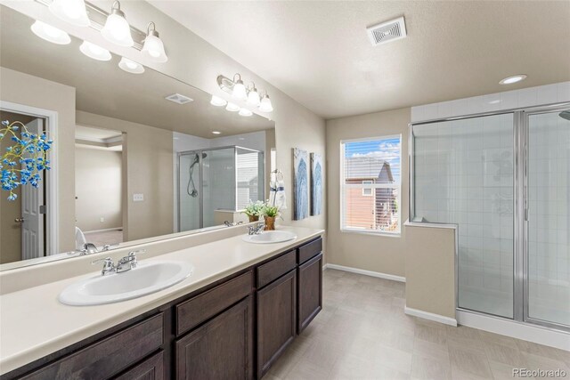 19131 E 65th Ave, Denver, CO 80249 - full bathroom with a stall shower, baseboards, double vanity, and tile patterned floors