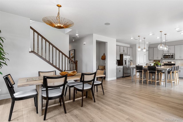 16897 W 92nd Dr, Arvada, CO 80007 - dining room featuring light wood-type flooring, a chandelier, stairway, and recessed lighting