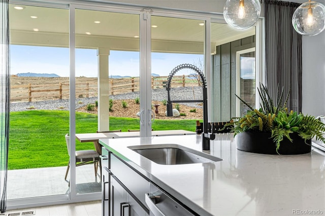 16897 W 92nd Dr, Arvada, CO 80007 - kitchen view of decorative light fixtures, recessed lighting, dishwasher, and light stone counters