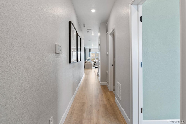 16897 W 92nd Dr, Arvada, CO 80007 - hallway with light wood finished floors, a textured wall, and recessed lighting