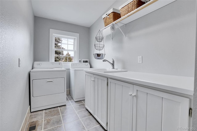 clothes washing area with cabinet space, visible vents, washer and dryer, a sink, and light tile patterned flooring