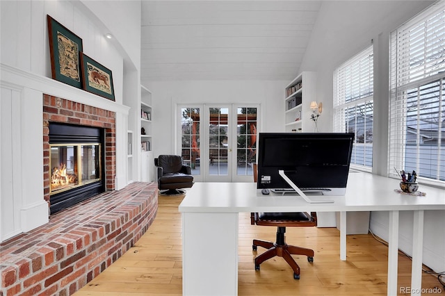 office space featuring french doors, built in features, hardwood / wood-style floors, and a healthy amount of sunlight