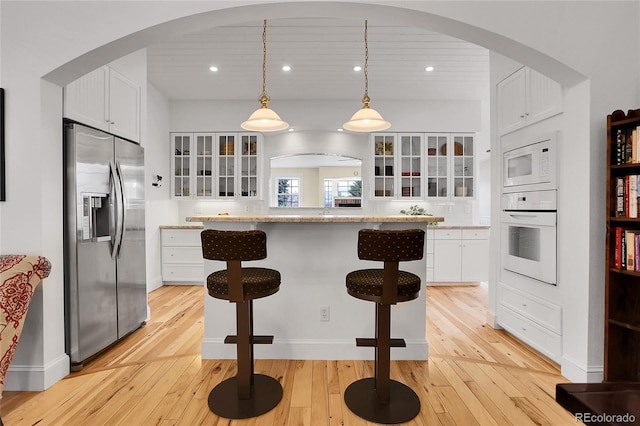 kitchen featuring white appliances, glass insert cabinets, and white cabinets