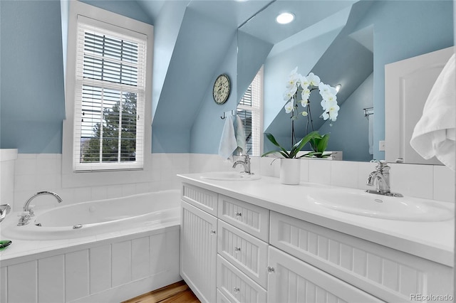 bathroom with a sink, a bath, and double vanity