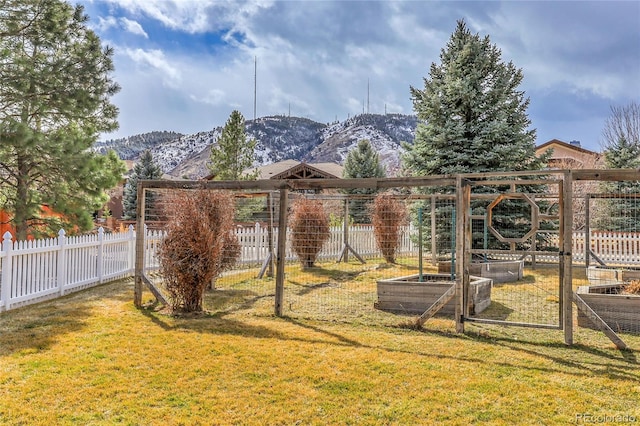 view of yard featuring a garden, fence, and a mountain view