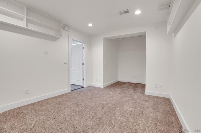 carpeted spare room featuring recessed lighting, visible vents, and baseboards