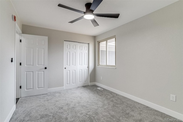 unfurnished bedroom with carpet flooring, a closet, visible vents, baseboards, and ceiling fan
