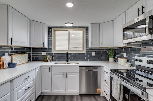 kitchen with stainless steel appliances, white cabinets, and a sink