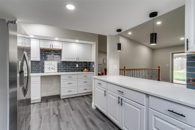 kitchen with decorative backsplash, stainless steel fridge, light countertops, and wood finished floors