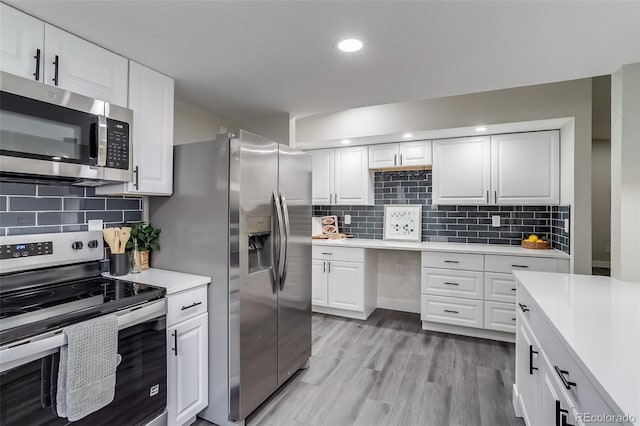 kitchen with tasteful backsplash, white cabinetry, light countertops, and appliances with stainless steel finishes