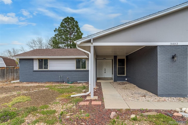 entrance to property with fence and brick siding