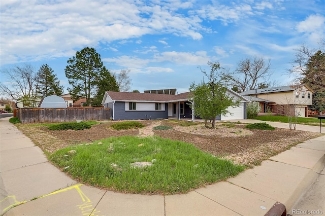 ranch-style house featuring driveway, a garage, and fence