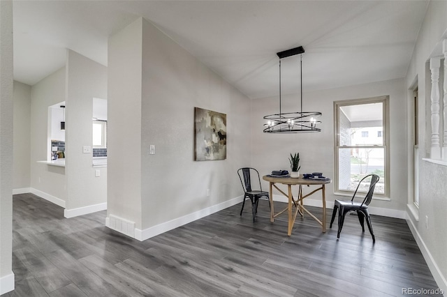 dining area with an inviting chandelier, dark wood-type flooring, and baseboards