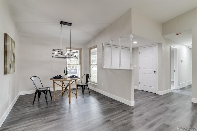 dining room with baseboards, a notable chandelier, and wood finished floors
