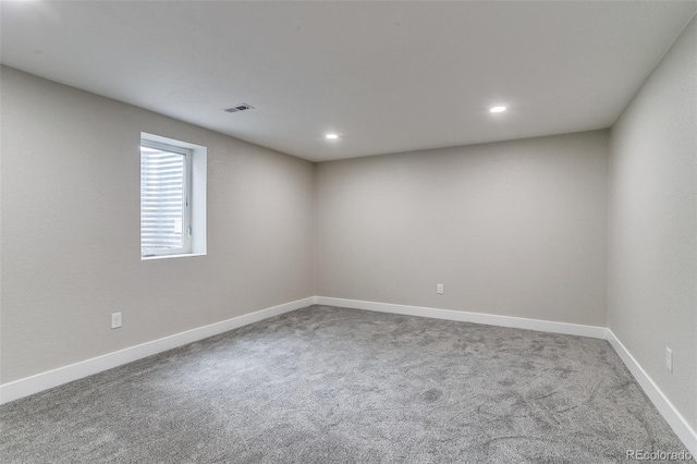 empty room featuring baseboards, visible vents, recessed lighting, and carpet