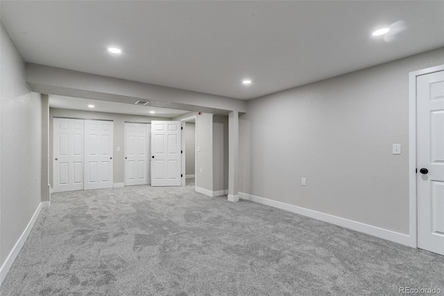 unfurnished bedroom featuring recessed lighting, carpet, baseboards, visible vents, and multiple closets