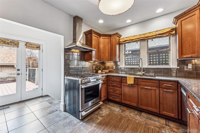 kitchen with wall chimney range hood, stainless steel gas range, a sink, and backsplash