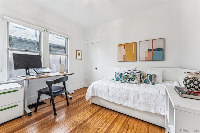 bedroom with wood finished floors and baseboards