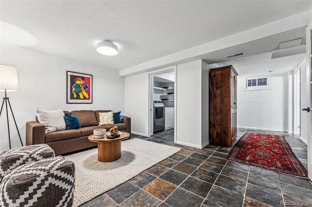 living room featuring stone finish floor, visible vents, and baseboards