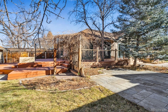 back of house with a patio area, a hot tub, fence, and a deck