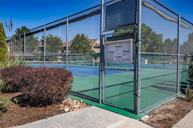 view of tennis court featuring a gate and fence