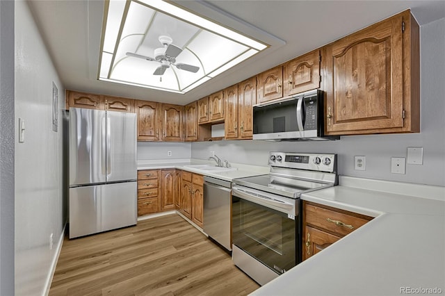 kitchen featuring brown cabinets, light wood-style floors, appliances with stainless steel finishes, and ceiling fan