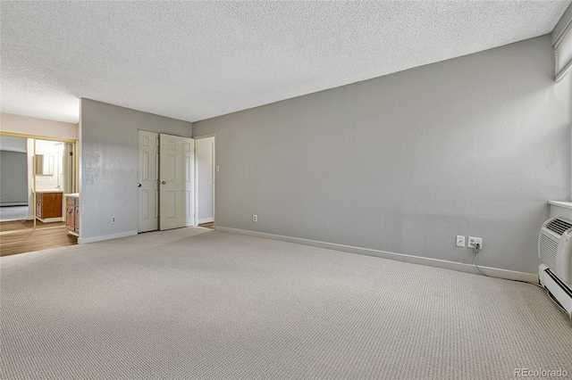 unfurnished bedroom with light colored carpet, a textured ceiling, connected bathroom, and baseboards