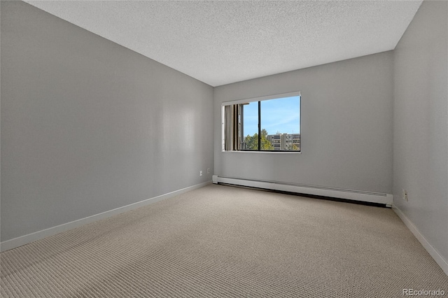 carpeted spare room featuring a baseboard heating unit, baseboards, and a textured ceiling